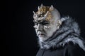 Alien, demon, sorcerer makeup. Demon on black background, copy space. Man with thorns or warts in fur coat. Theatrical