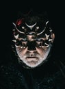 Alien, demon, sorcerer makeup. Man with third eye, thorns or warts. Demon on black background, close up. Senior man with