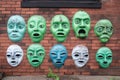alien faces, with their eyes and mouths cut out, spray-painted on a brick wall