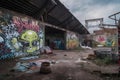 alien street artist spray painting mural of extraterrestrial life on the walls of abandoned warehouse