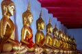 Aligned golden buddha statues.