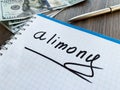 Alimony written on a notepad. Divorce and separation concept.