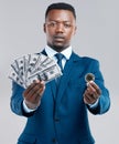 All of this could be yours. Studio shot of a young businessman holding US dollars and a bitcoin against a grey