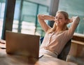 All in a days work. a content young businesswoman leaning back in her chair with her hands behind her desk. Royalty Free Stock Photo