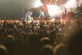 All eyes fixed on the stage. Rear view shot of a packed audience watching a great musical act with their hands raised.