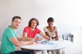 We all have a job to do. three businesspeople gathered around a table in the office.