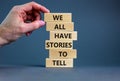 We all have stories to tell symbol. Wooden blocks with words `We all have stories to tell`. Businessman hand. Beautiful grey