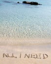 All I need message written on white sand, with tropical sea waves in background