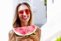 All Inclusive Cheap Summer Holidays. Young Happy Woman with Watermelon and pink sunglasses at beach Background. Summertime fun Royalty Free Stock Photo