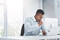 All the long days at the office will prove fruitful. a young businessman sitting at his office desk yawning and looking