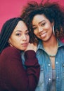 We all need somebody to lean on. Portrait of two girlfriends posing against a pink background.