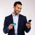 All our dreams can come true. Shot of a handsome businessman standing against a grey studio background and using his Royalty Free Stock Photo