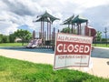 All playgrounds closed for public safety sign as Coronavirus with colorful kid park in background