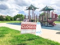 All playgrounds closed for public safety sign as Coronavirus with colorful kid park in background