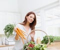 All the right ingredients for a nice minestrone soup. A gorgeous woman holds a bunch of carrots while looking into her Royalty Free Stock Photo