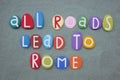 All roads lead to Rome, italian proverb composed with stone letters over green sand