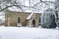 All Saints church in the small village of Sutton in the British countryside, it is totally covered in deep snow during a rare snow Royalty Free Stock Photo