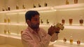 A perfumer wearing a white uniform mixing perfume in a perfumery, Bahrain