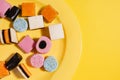 All sort licorice candies on bright yellow plate, diet and sugar Royalty Free Stock Photo