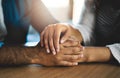 All it takes is a loving hand. a man and woman compassionately holding hands at a table.