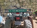 all-terrain vehicle ATV parked on a street with a motivational plate text