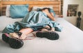 All time ready for trekking. Hiker female sleeping in comfort trekking boots. Footwear on the bed sheet background concept image. Royalty Free Stock Photo