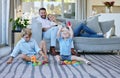 All they wanna do is play. Full length shot of an affectionate family of four relaxing in the living room at home.