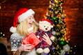 All she wants for christmas. Cheerful woman. Woman got teddy bear toy present. Santa hat christmas accessory. Cute gift Royalty Free Stock Photo