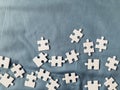 all-white jigsaw puzzle pieces on a green-blue fabric background Royalty Free Stock Photo