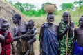 All women with their infants in bright clothes posing to the tourists in the local Mursi tribe village