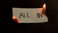 All in word written on white paper burns. Fire with smoke and ashes on black background Royalty Free Stock Photo