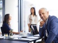 It all works out in the end. a handsome middle aged businessman sitting in a boardroom with his colleagues in the Royalty Free Stock Photo