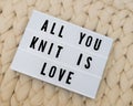 ALL YOU KNIT IS LOVE word on lightbox on knit background. Cozy compozition. Knit WOOL background. Royalty Free Stock Photo