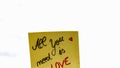 All you need is love handwriting text close up isolated on yellow paper with copy space