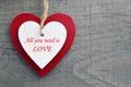 All you need is Love.Valentine`s Day greeting card.Decorative red and white wooden hearts on a grey wooden background. Royalty Free Stock Photo