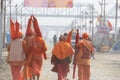 A team of Hindu Sadhus wearing saffron clothes walking on the pilgrim route to holy Sangam.