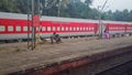 An Indian Railways train painted red parked on a platform of a railway station