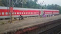 An Indian Railways train painted red parked on a platform of a railway station