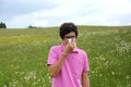 Allergic adolescent with glasses blows his nose Royalty Free Stock Photo