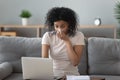 Allergic african woman blowing nose in napkin sit at home Royalty Free Stock Photo