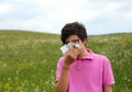 Allergic boy blows his nose with white handkerchief in springtim Royalty Free Stock Photo