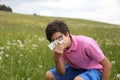 Allergic boy with glasses blows his nose Royalty Free Stock Photo