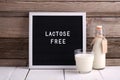 Allergic food concept. Milk bottle, milk glass and letter board with text LACTOSE FREE on wooden background Royalty Free Stock Photo