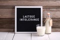Allergic food concept. Milk bottle, milk glass and letter board with text LACTOSE INTOLERANCE on wooden background Royalty Free Stock Photo