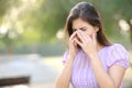 Allergic woman scratching eyes in a park Royalty Free Stock Photo