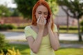 Allergie make trouble in nose! Young redhair woman sneezing. Pollen Allergy symptoms