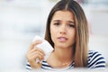 Allergies got you down. Portrait of a young woman suffering from allergies holding a tissue at home. Royalty Free Stock Photo