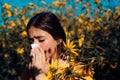 Allergy medical seasonal flowers concept. Woman with napkin fighting blossom allergie outdoor. Allergy to flowering