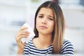 Allergy season already. Portrait of a young woman suffering from allergies holding a tissue at home. Royalty Free Stock Photo