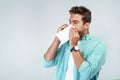 Allergy, sick and man blowing nose in tissue with flu, illness and virus on studio background. Health mockup, wellness Royalty Free Stock Photo